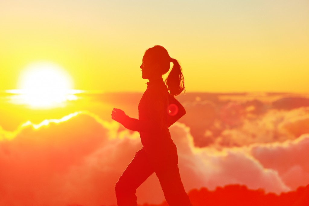 Runner woman running in sunshine sunset